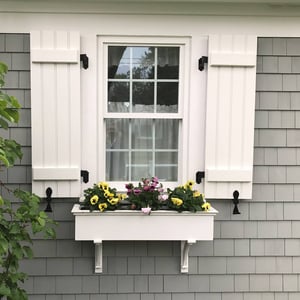 White closed Board and Batten shutters on gray home