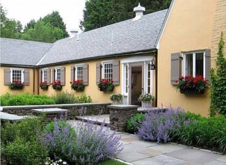 gray board and batten shutters on tan stucco cottage