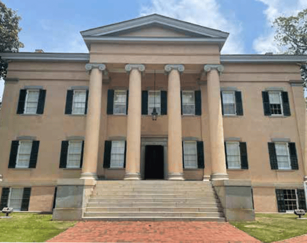 A Greek Revival mansion with Shutters on Every window