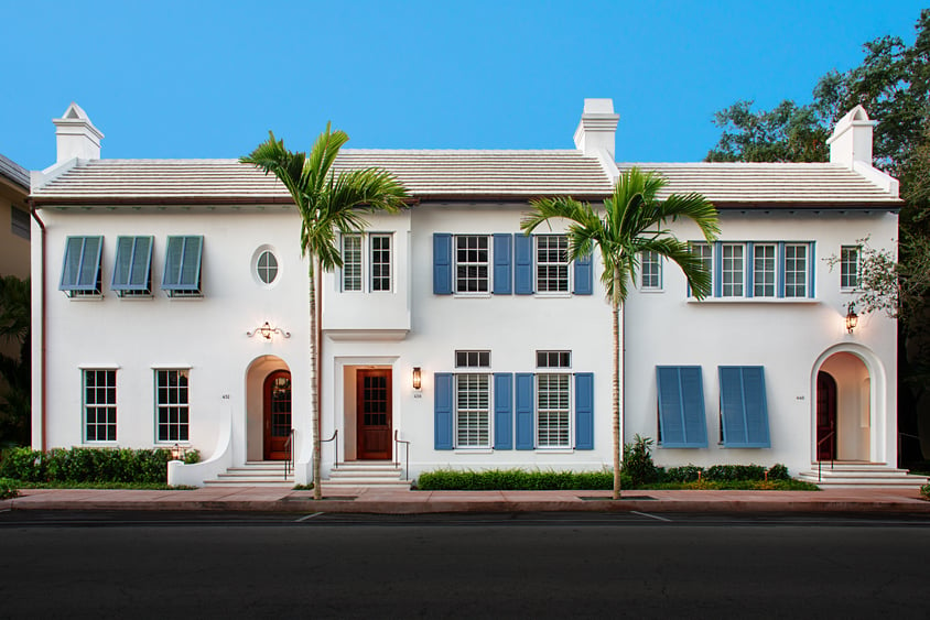 Blue panel and bermuda shutters white stucco house front-1