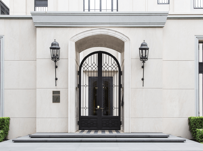 front view of the main entrance to an elegant luxury home with symmetrical line detail throughout