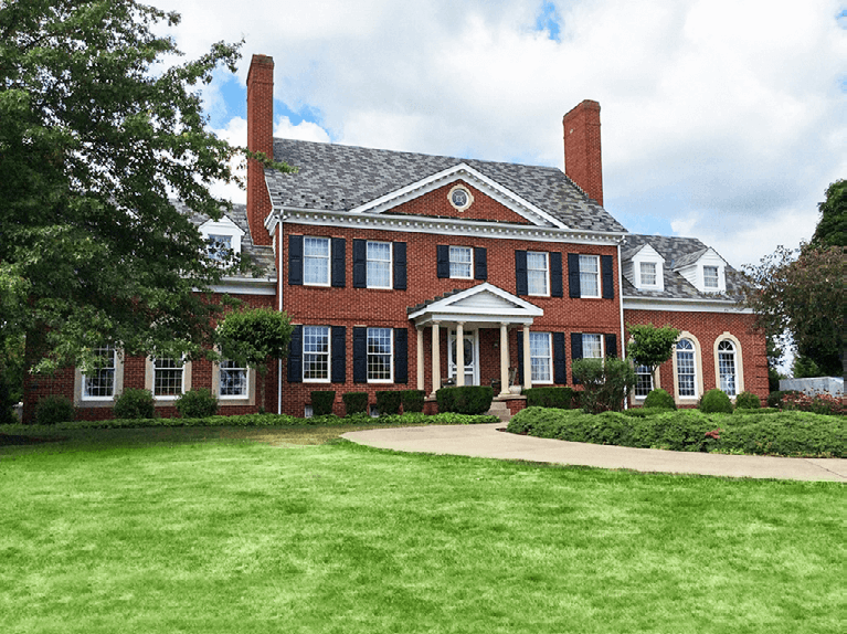red brick colonial style home with black Timberlane panel shutters with functional shutter hardware