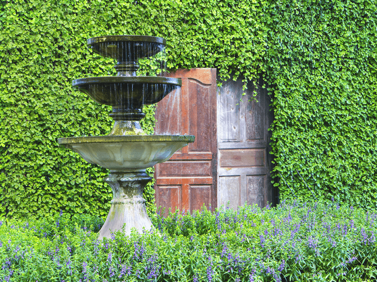 centerfold featuring an elegant stone water fountain within an exterior garden space