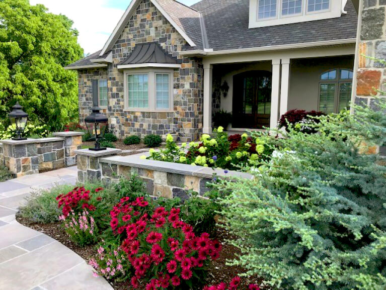 front entrance of stone veneer home with custom panel exterior shutters