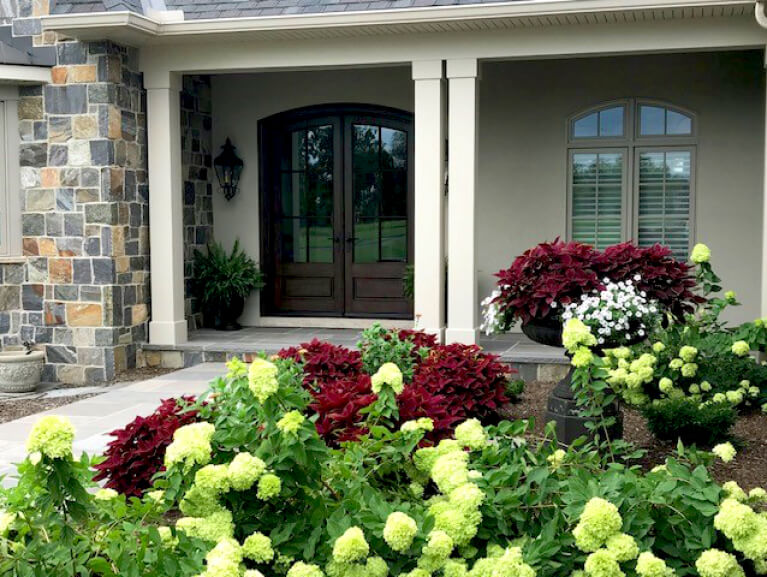 close up view of a custom front door accompanied by a garden in the entry courtyard