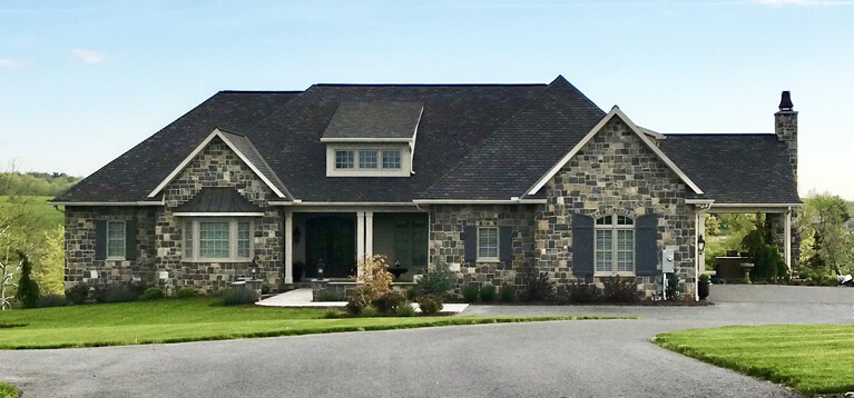 custom home with stone exterior and custom panel exterior shutters