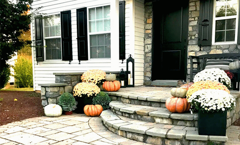 slideshow of different homes with Fall decor including warmer tones of color, hay, corn and pumpkins