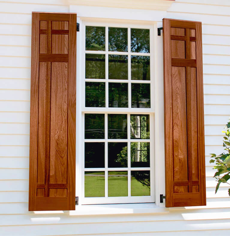 home with white siding and wooden mission style exterior shutters with functional shutter hardware