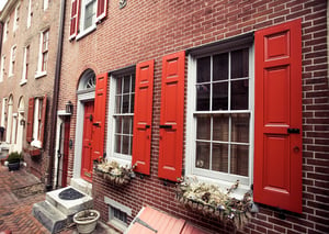 Red panel shutters on brick home in Elfreth's Alley