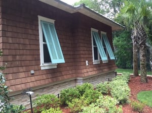 Light blue bermuda shutters on brown home