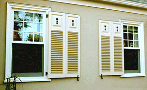 white louver and panel combination shutters with flower cutouts
