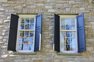 blue panel shutters on tan stone home