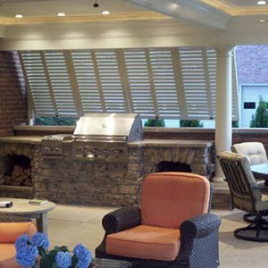 White bermuda shutters are add shade and privacy to an outdoor grille area