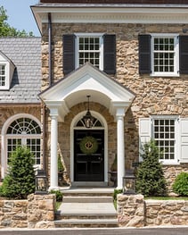 front facade of home with black louver shutters and white panel shutters