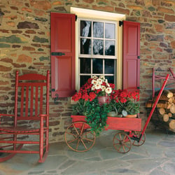 rED PANEL SHUTTERS ON TAN STONE HOME