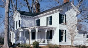 Timberlane's operable louver, radius-top black shutters on a house with white siding.