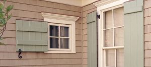 green board and batten shutters on gray house