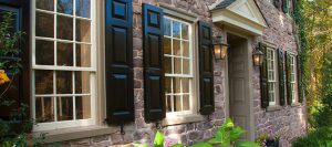 black panel shutters on stone home