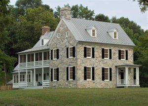 stone colonial farmhouse with panel shutters and louver shutters