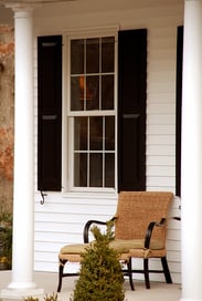 Custom black panel shutters on a front porch