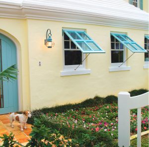 The turquiose shade of these Bermuda shutters was custom matched to make this warm façade come alive with pops of cool color. Bermuda shutters are perfect for shade, breeze, and privacy.