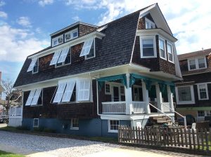 White bermuda shutters on dark brown beach home