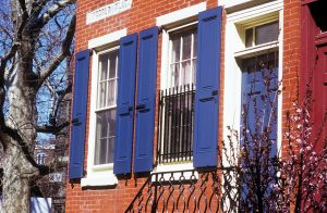 These vibrant blue recessed panel shutters brighten up the brick façade of this historic townhome.