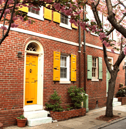 yellow and green panel shutters on brick home