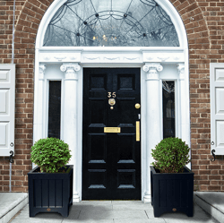 white panel shutters on brick home entrance