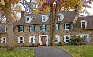 A combination of Timberlane's panel and louver shutters in both green and white on a stone colonial.