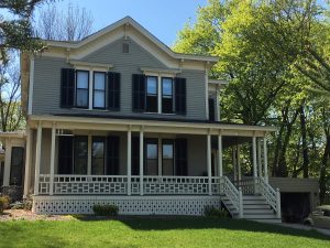 Italianate style home with custom louver shutters in black.