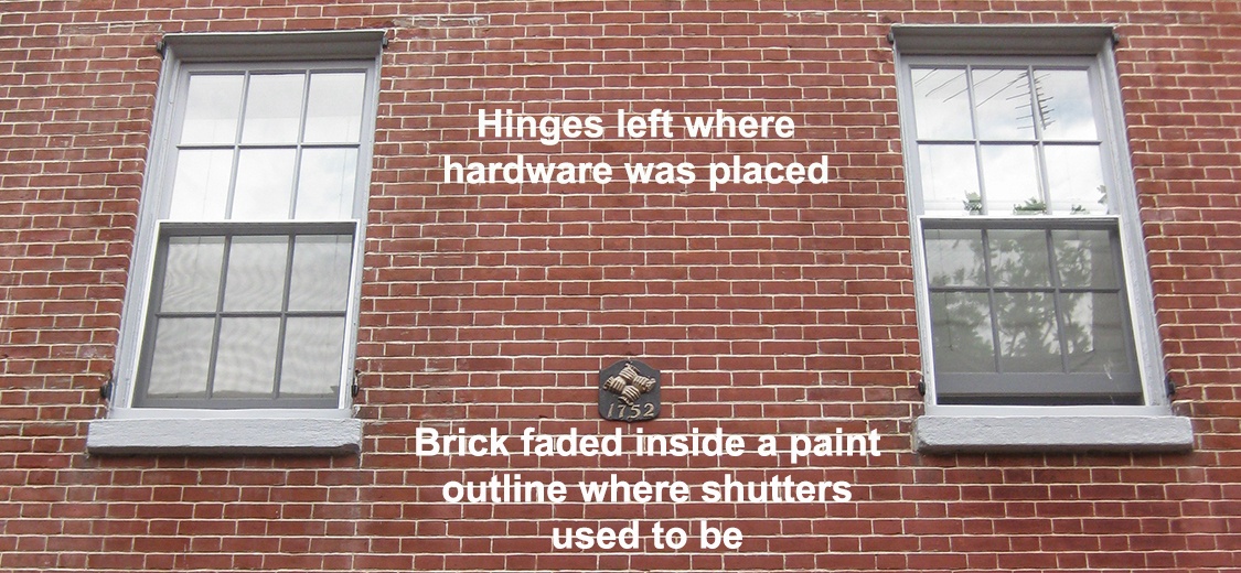 missing shutters on windows on a brick wall