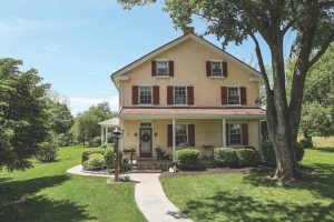 Red panel shutters on yellow stucco house