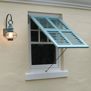 Light blue bermuda shutter on white stucco beach home