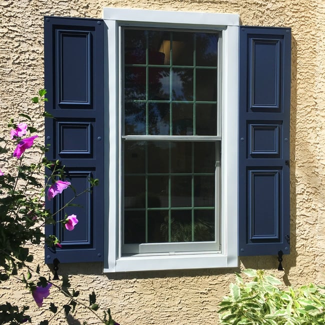 JVC dark blue panel shutters on tan stone and stucco house single window social edit