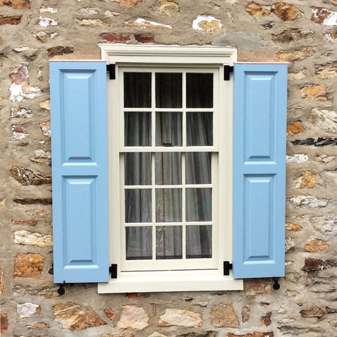 Light blue panel door shutters tan stone house single window social edit
