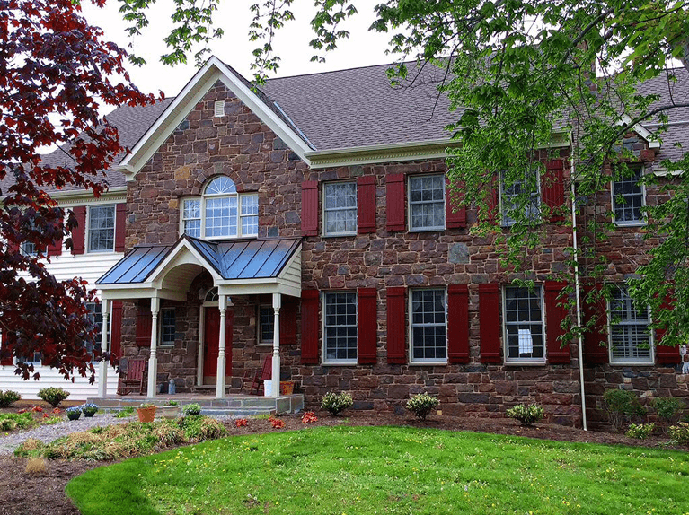 red board and batten exterior shutters for a stone home