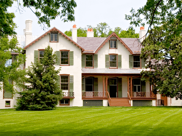 green louvered shutters for historic stucco home