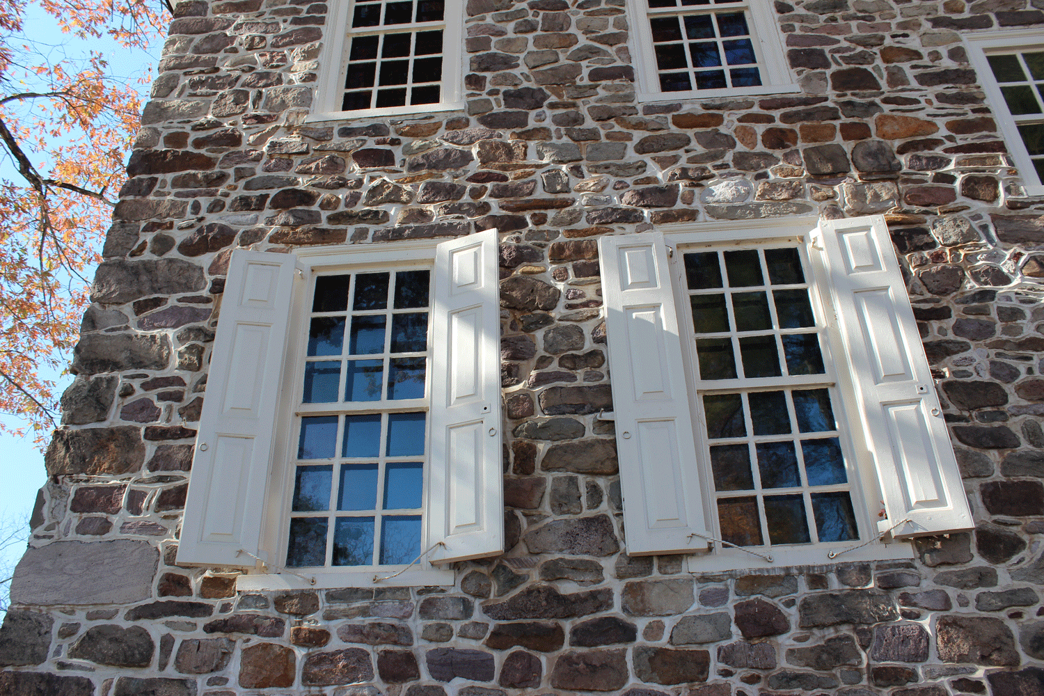 Panel A Surprisingly Versatile Window Shutter Timberlane Blog   B White Panel Shutters Brown Gray Stone House Front First Floor Windows 