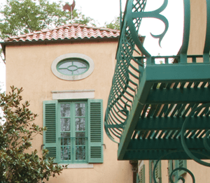 green louver shutters on peach stucco home