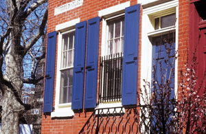 blue panel shutters on red brick home