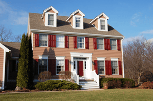 red panel shutters on tan brick home
