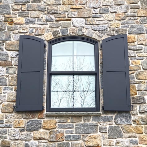 Delaware Project Grey Stone Exterior with Black Shutters Closeup Arched Panels 2 social edit