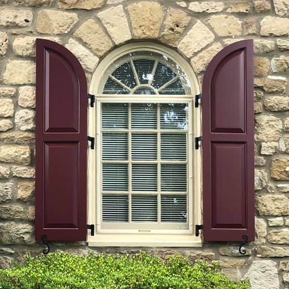 maroon panel arched top shutters stone exterior social edit